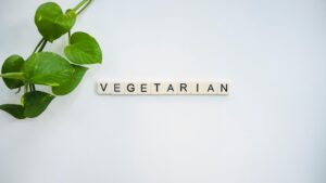 A simple and fresh vegetarian concept featuring green leaves and tiles spelling 'VEGETARIAN'.