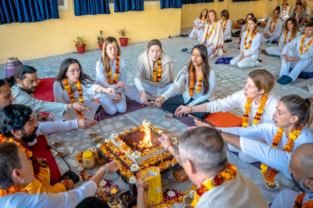 Group gathered for a traditional fire ceremony in Rishikesh, India, symbolizing unity and spirituality.