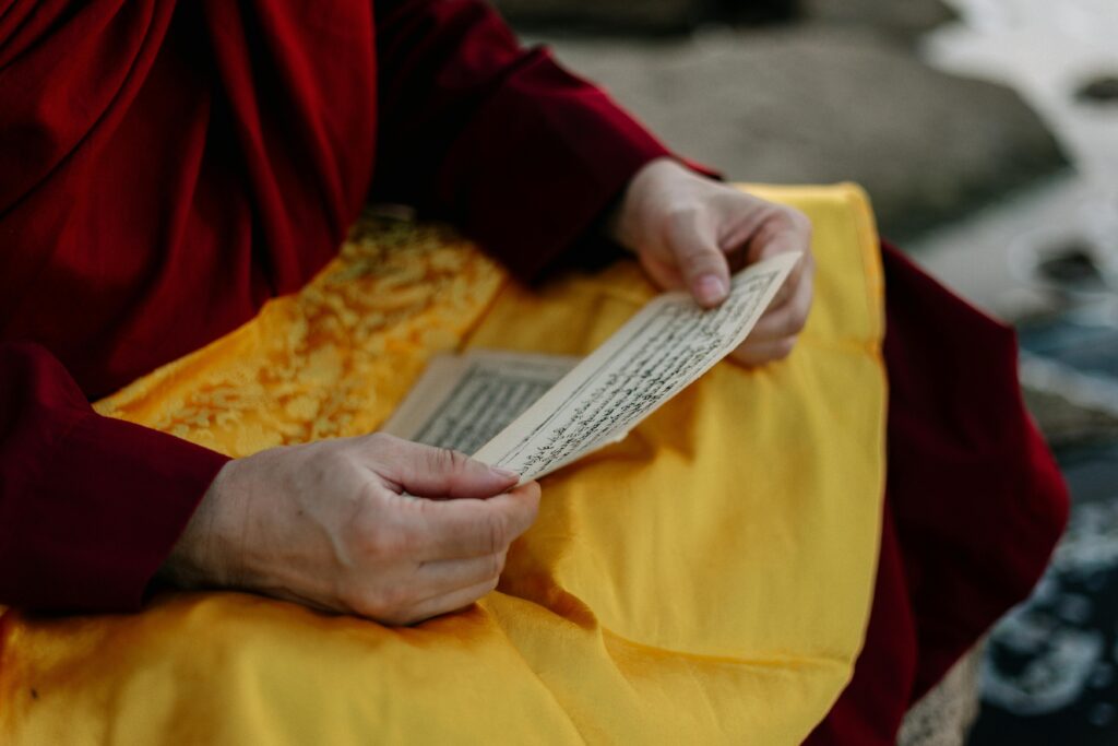 Close-up of a monk reading sacred text, highlighting ritual significance and serenity.