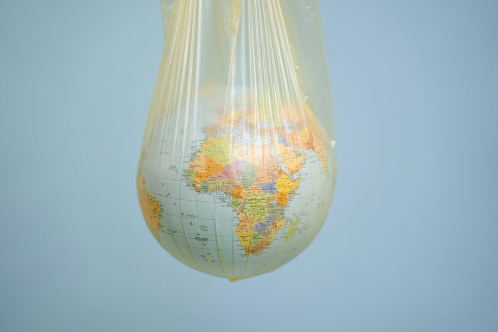 A globe wrapped in plastic highlighting global environmental issues.