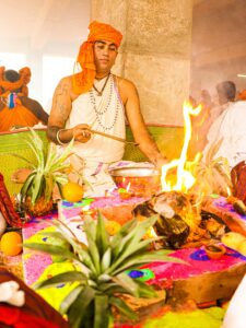 A vibrant Hindu fire ritual ceremony with offerings and traditional dress in Dhaka, Bangladesh.