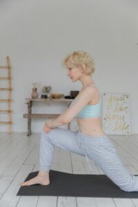 Woman practicing yoga in a serene indoor environment, promoting mindfulness and wellness.